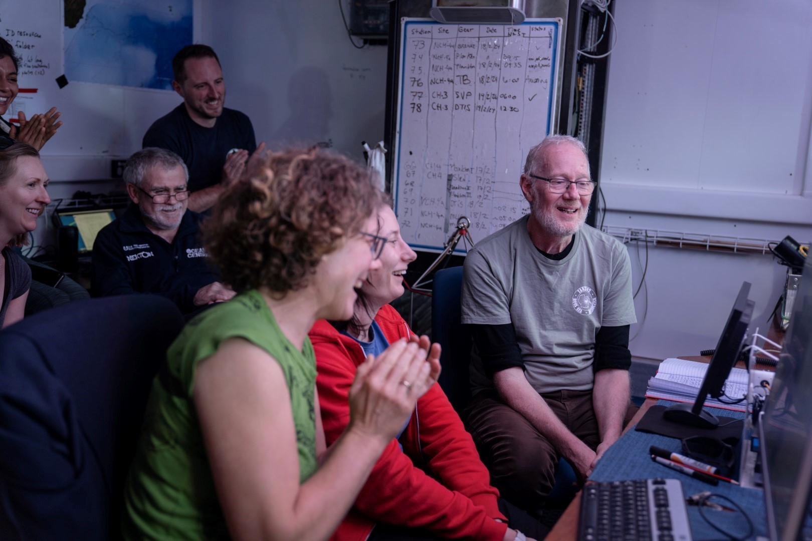 Happy researchers looking at monitor on board the research vessel Tangaroa